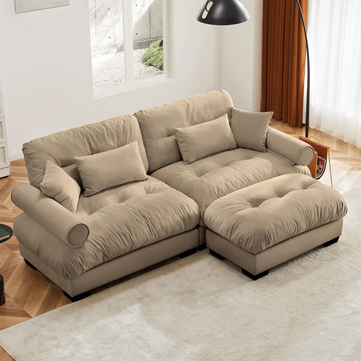 Camel velvet two-seater sofa with matching ottoman, round bolster armrests and scatter pillows