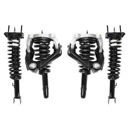 Four silver strut assemblies with black coil springs and mounting plates arranged on grey surface