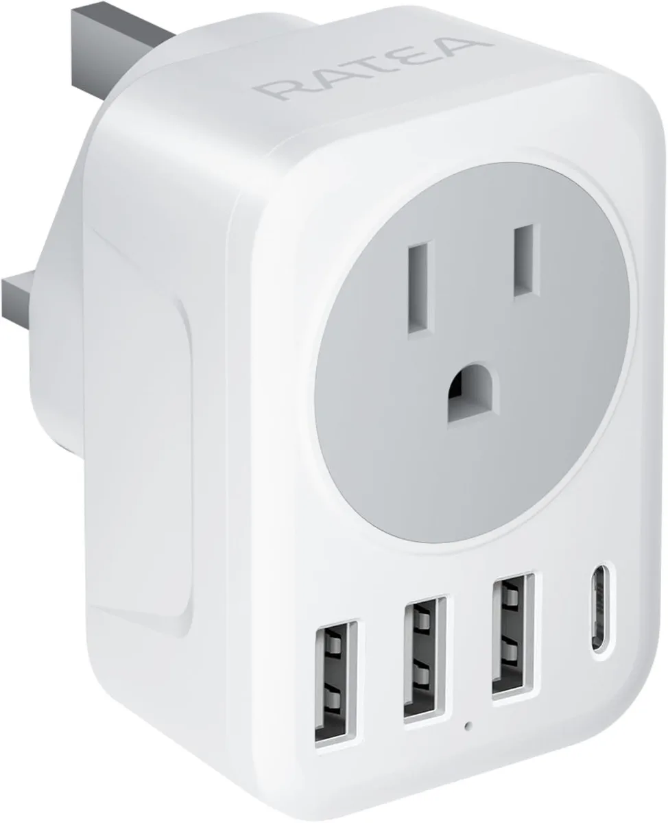 White-grey compact UK Type G travel adapter with three USB-A ports, one USB-C port and one AC outlet