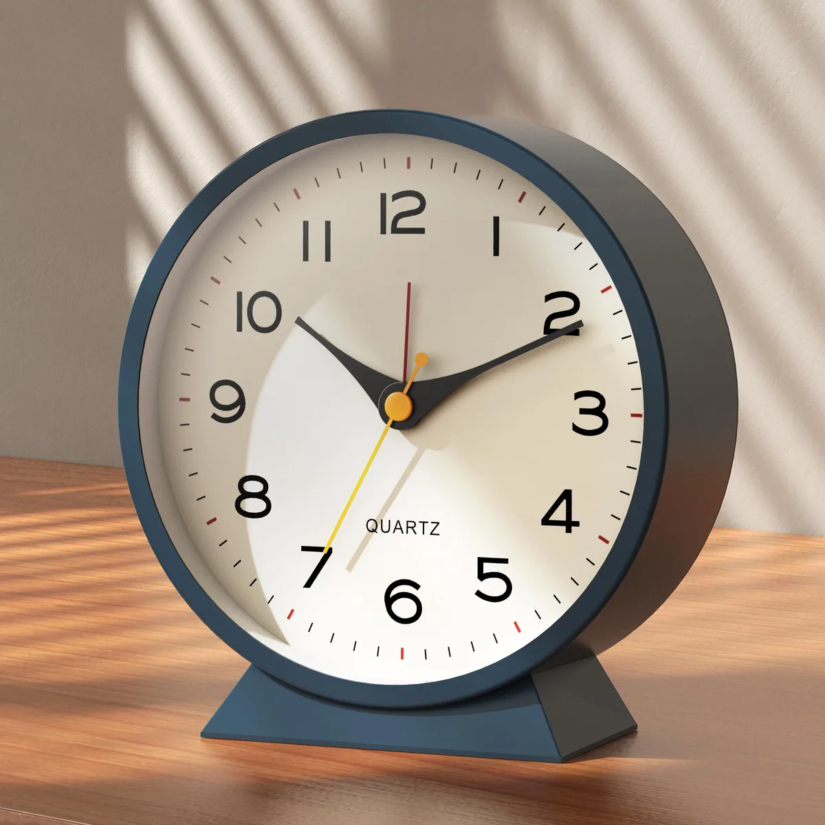 Small blue metal analog alarm clock with retro styling