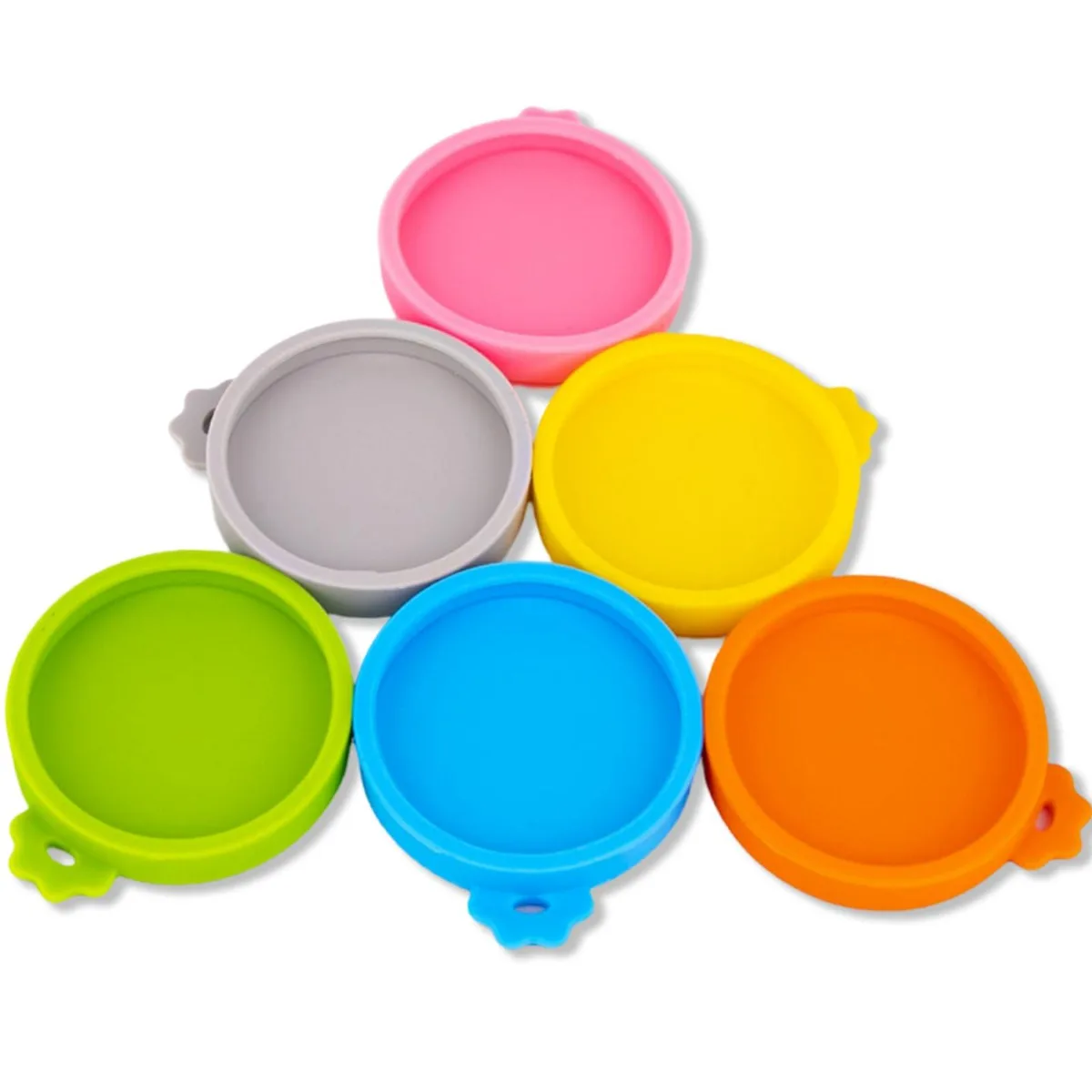 Six blue silicone can lids with pull tabs on a surface