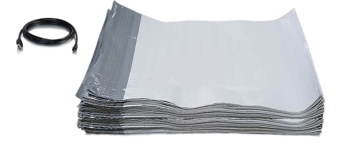 A stack of white poly mailers with a USB cable included