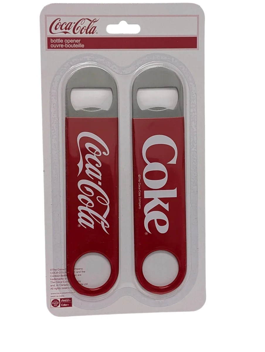 Two red metal bottle openers with white Coca-Cola logos on a blister card