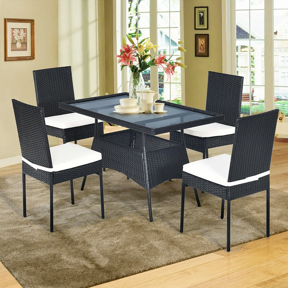 Five-piece rattan dining set with glass-top table and four cushioned chairs
