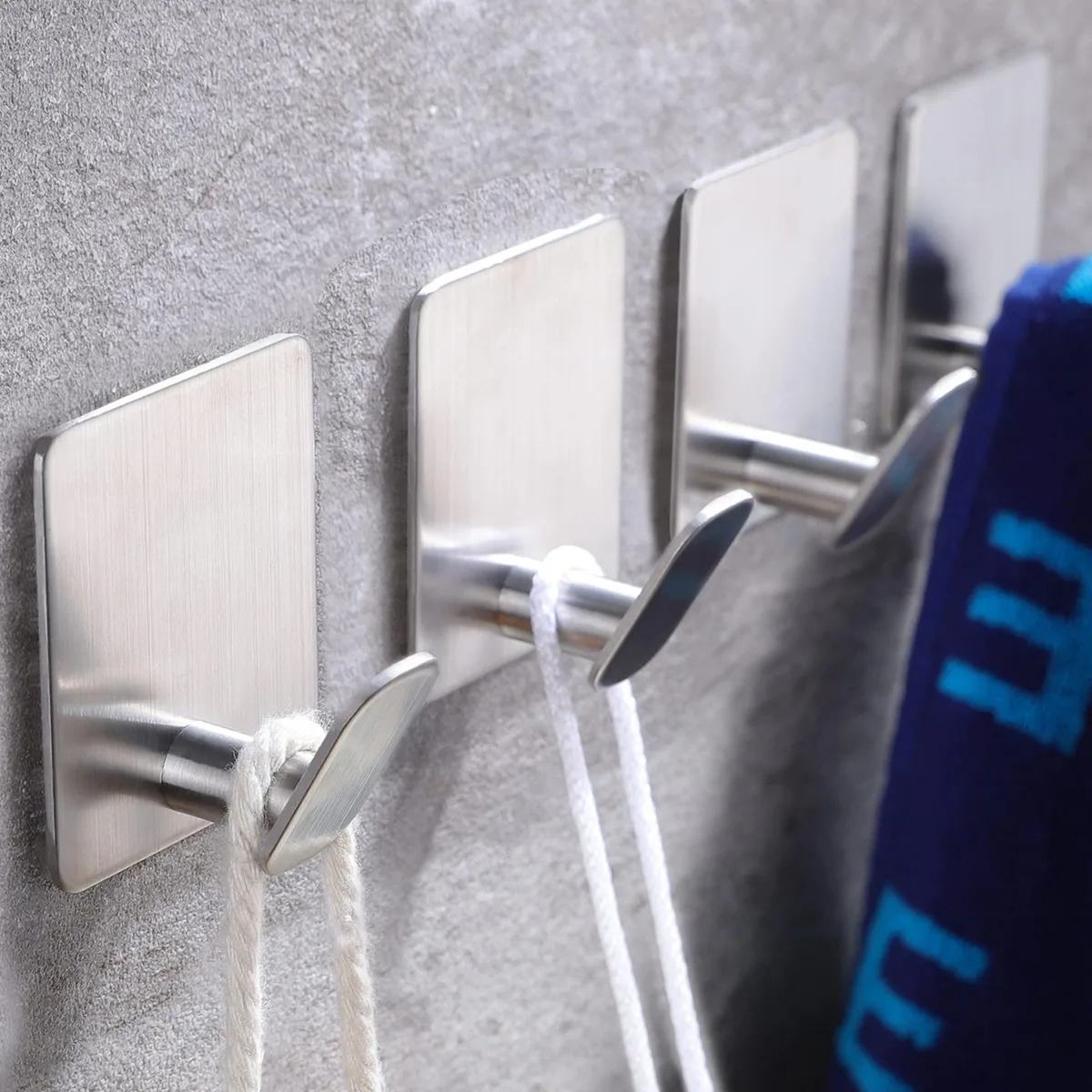 Four silver stainless steel adhesive hooks with brushed finish