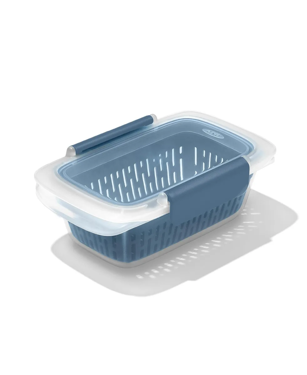 Red rectangular food storage container with clear windowed lid and removable colander insert