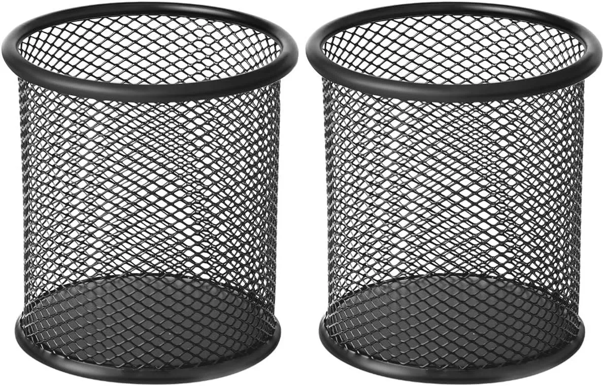 Two black mesh metal pen holders on a desk