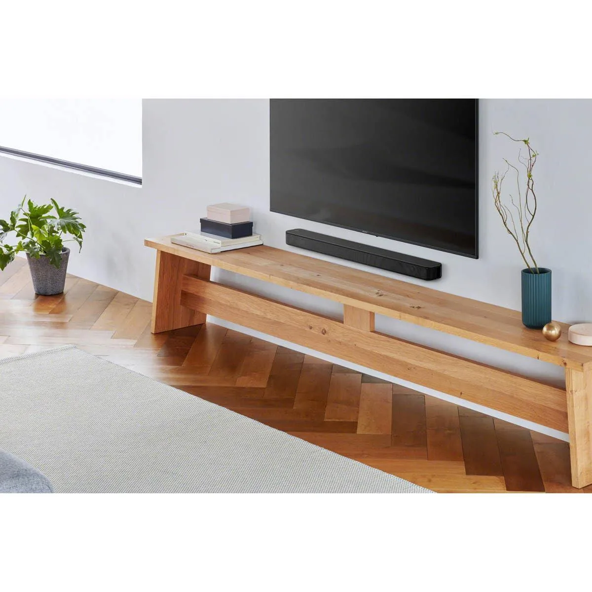 Slim black plastic soundbar with integrated tweeter and bass reflex port