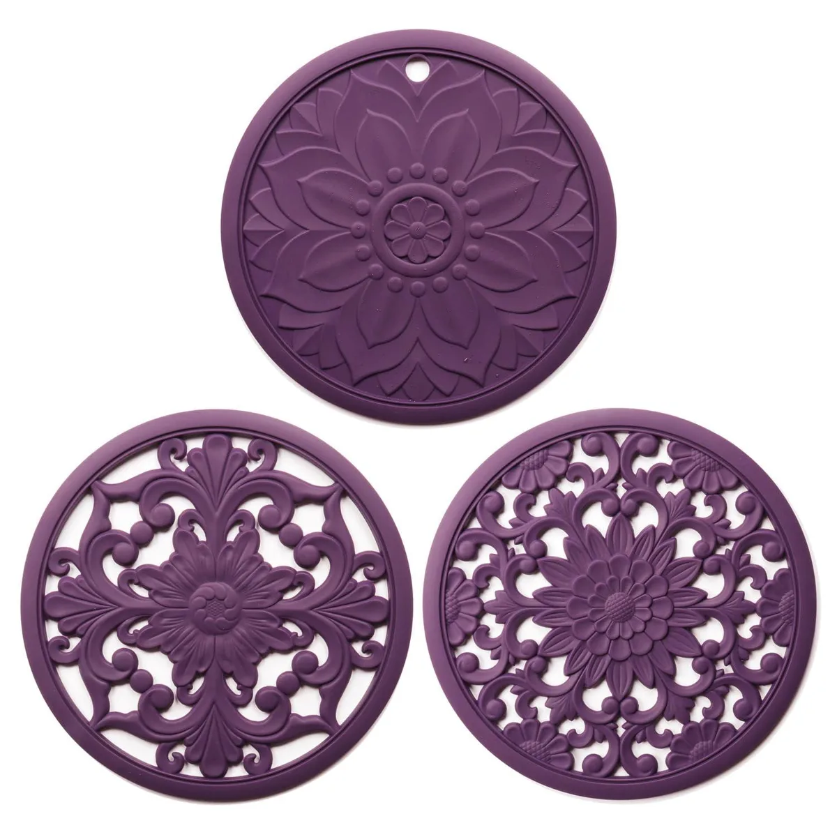 Three round purple silicone trivets with carved patterns