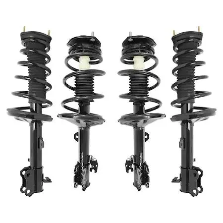 Four silver metal strut assemblies with coiled springs and top mounts on cardboard