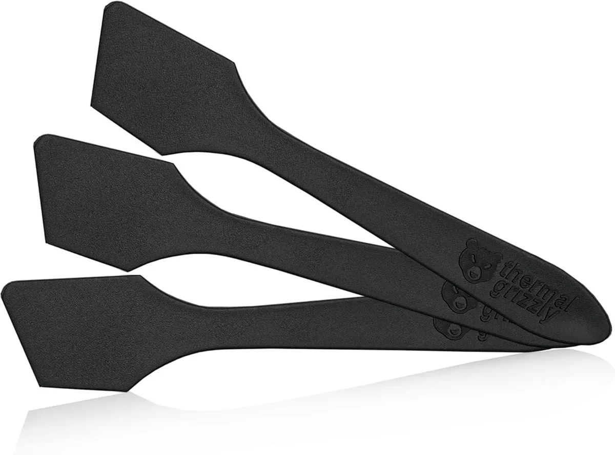 Three black plastic spatulas for spreading thermal paste