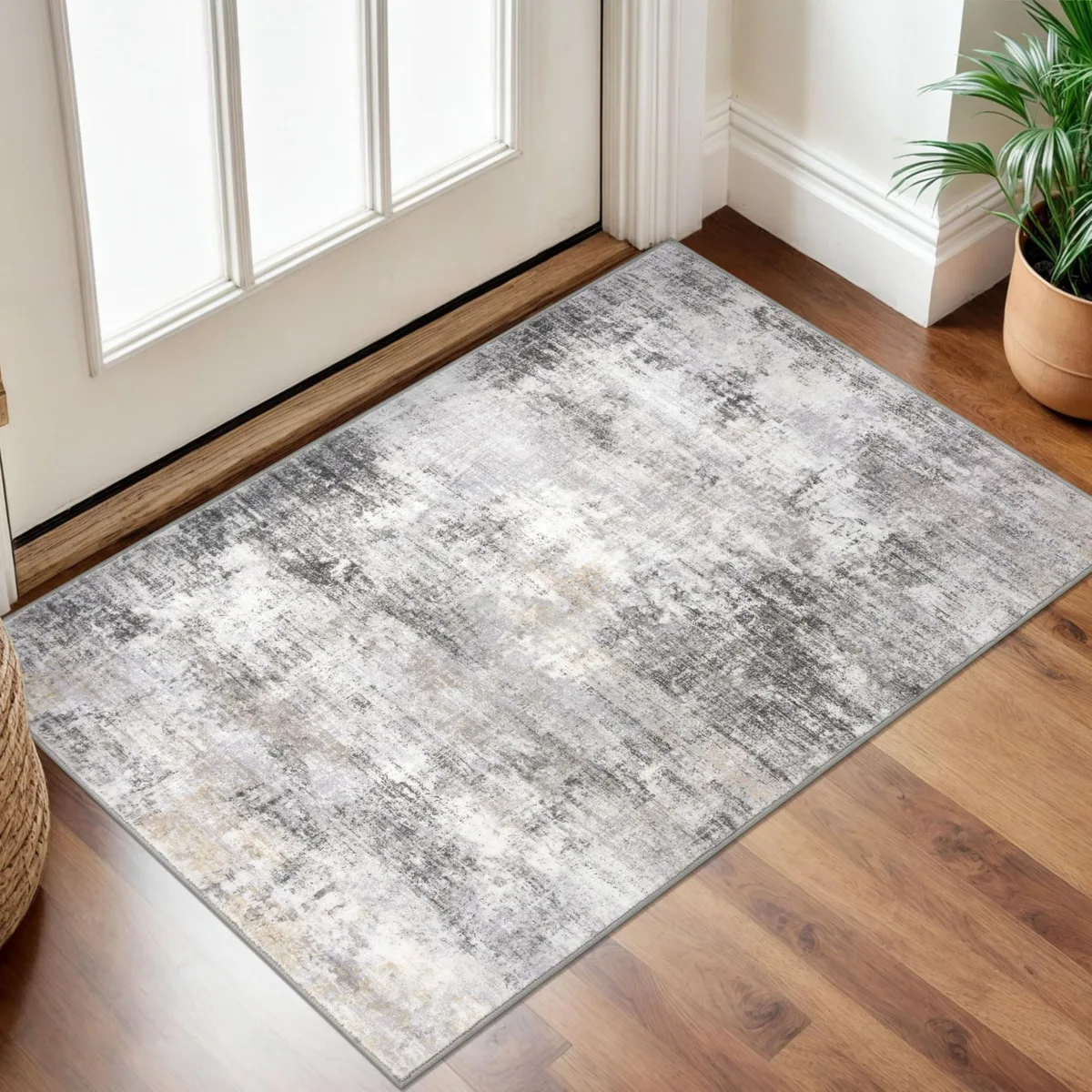 Rectangular 24 by 36 inch rug with abstract grey and beige print, TPE backing, folded flat