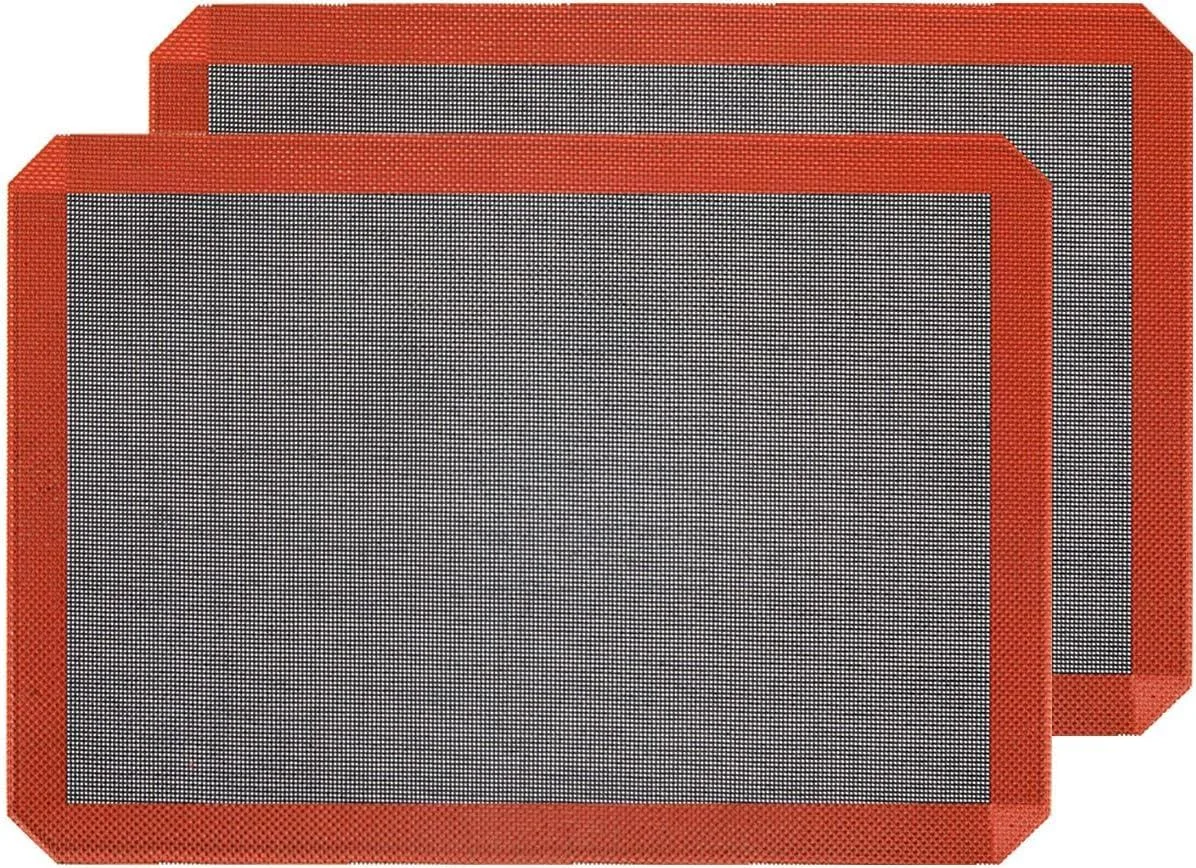 Two perforated silicone baking mats, rectangular with corner cuts, light checkered texture