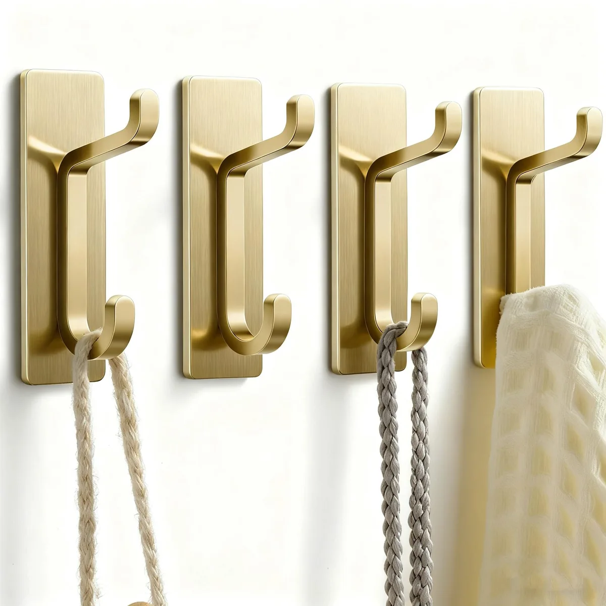Four gold stainless steel adhesive hooks on backing card