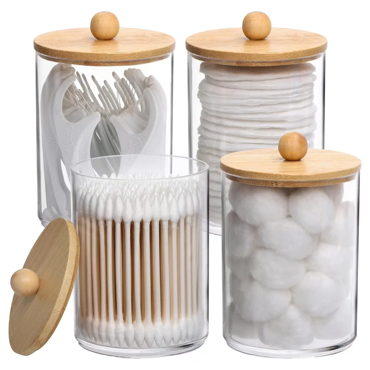 Four clear glossy plastic apothecary jars with natural bamboo lids