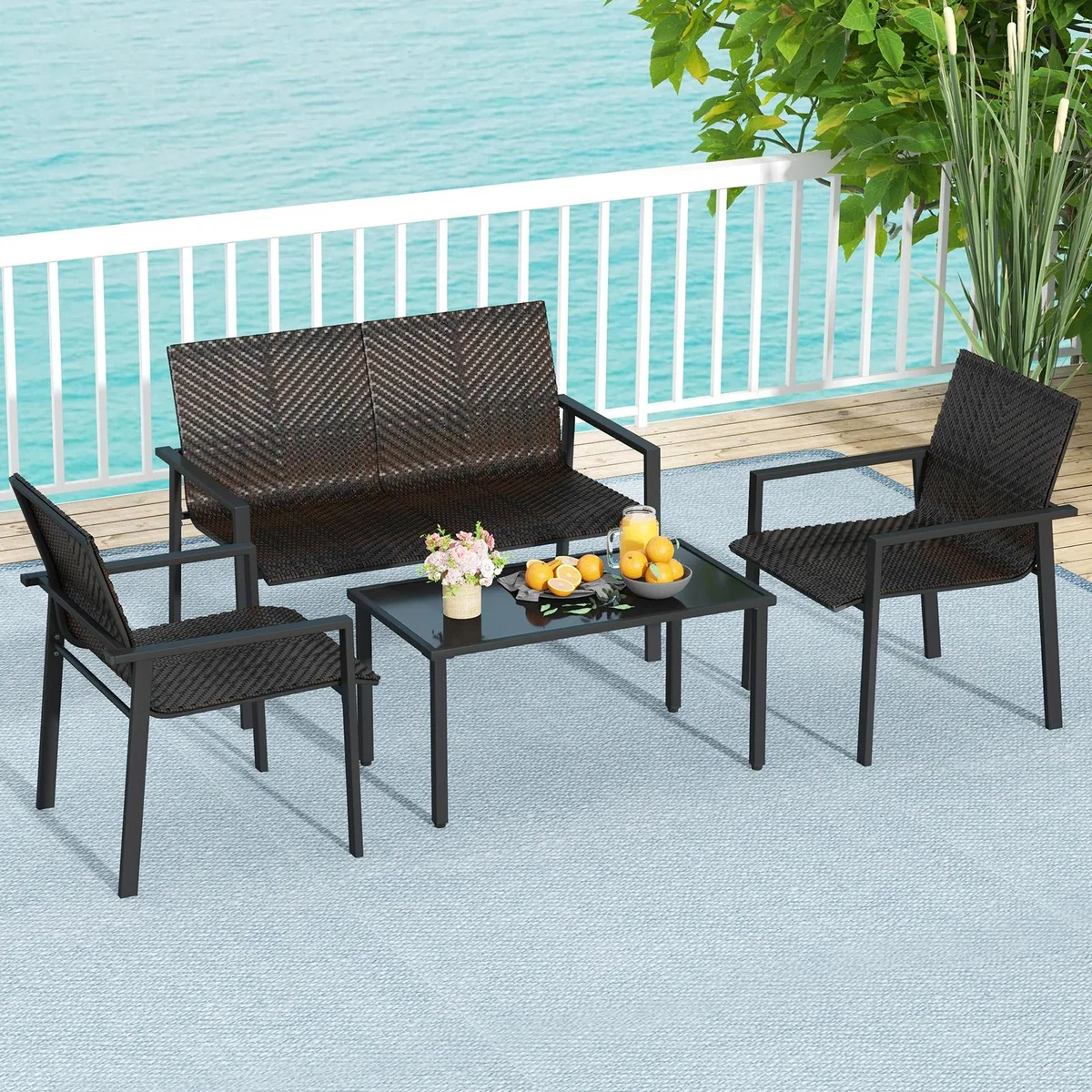 Brown PE rattan four-piece patio set with metal frame and glass-top coffee table