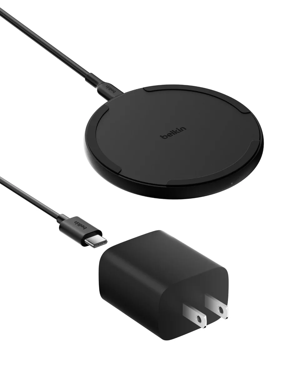 Black circular wireless charging pad with a matte finish and a USB-C cable attached