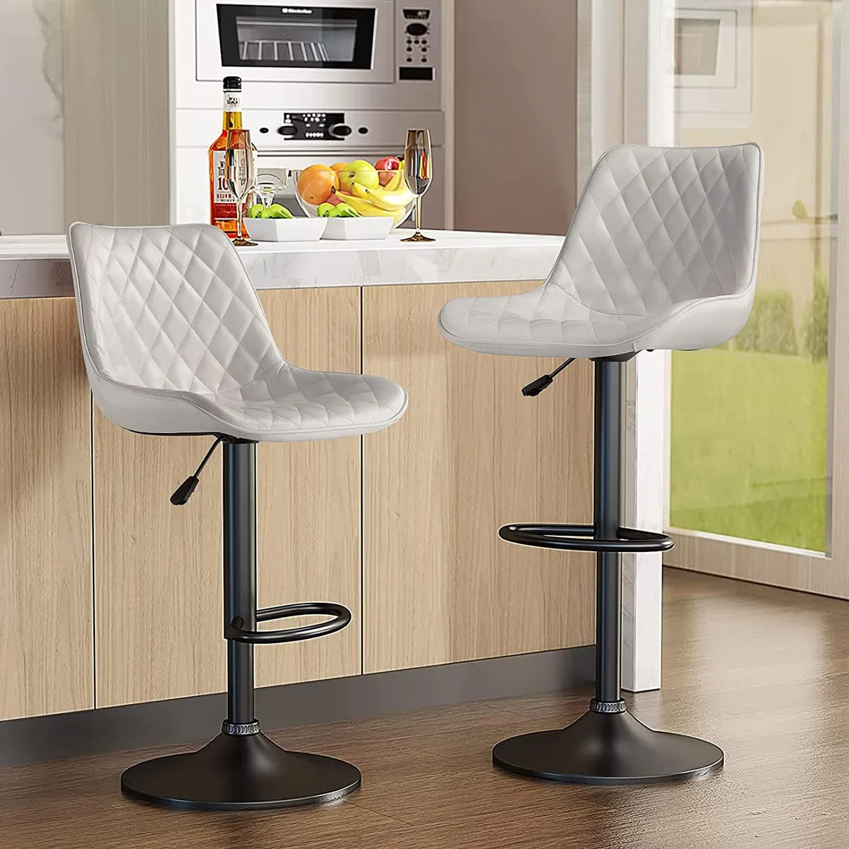 Two white adjustable swivel barstools with backrests and footrests, faux leather seats, chrome gas lift and wide round base