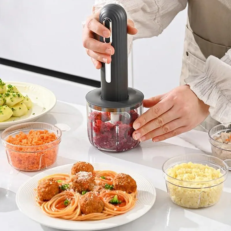 Gray wireless food processor, compact cube shape, matte finish, stainless steel blades visible inside