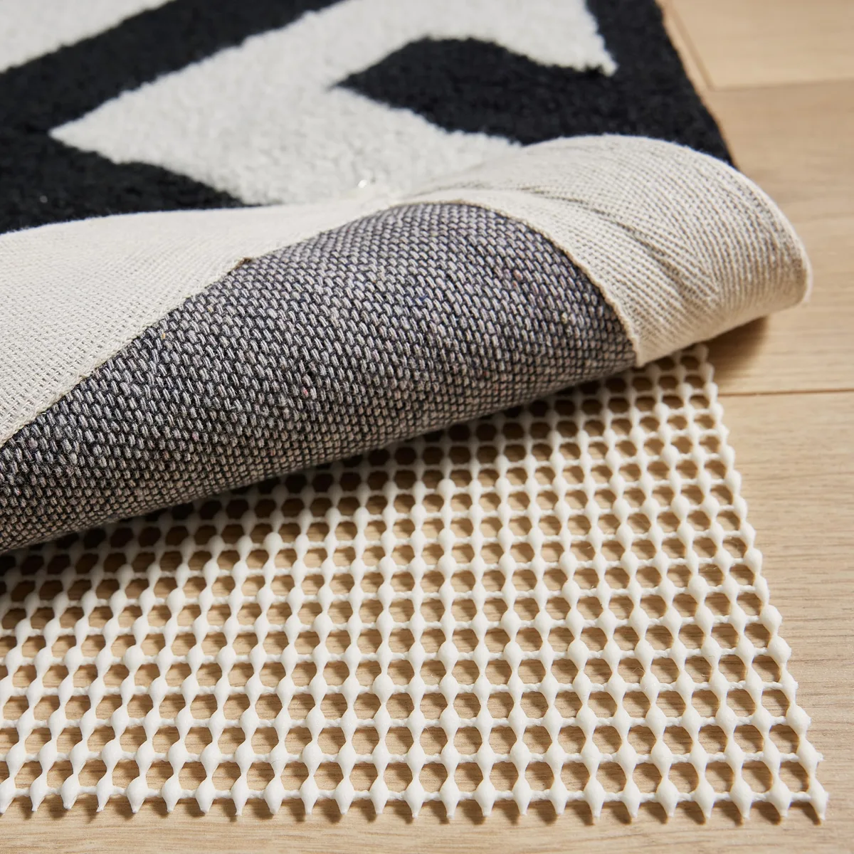 Rectangular cream vinyl rug gripper pad, 2 by 3 feet, thin open-grid texture