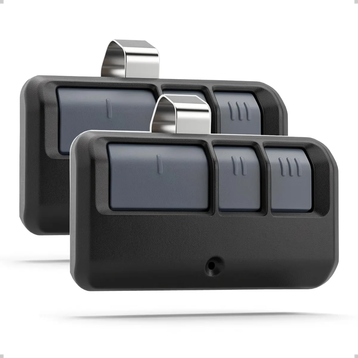 Two black three-button garage remotes with stainless steel visor clips