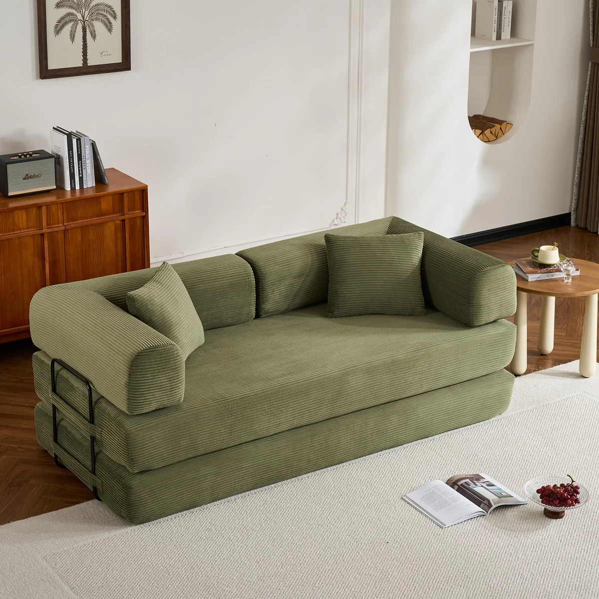 Green corduroy convertible sleeper sofa with cylindrical pillow, folded as a couch
