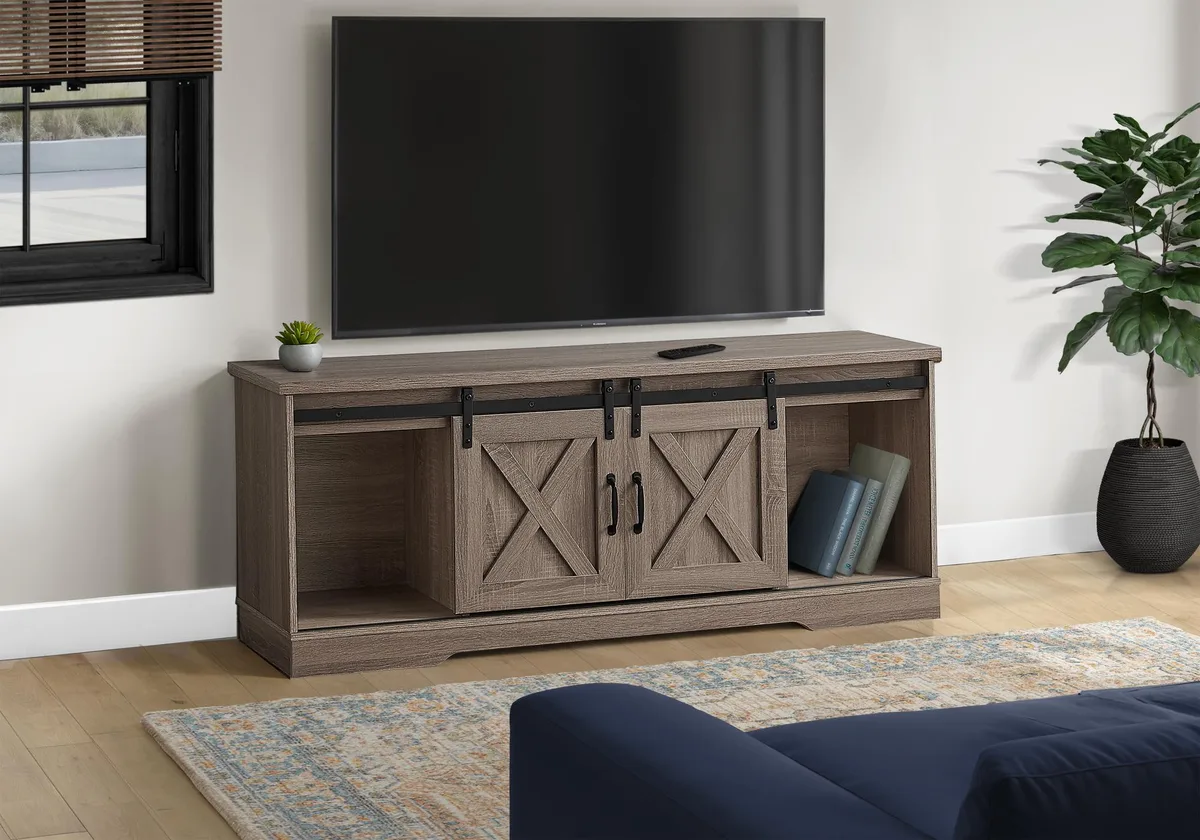 Low brown laminate TV stand with two barn-style sliding doors on black metal track