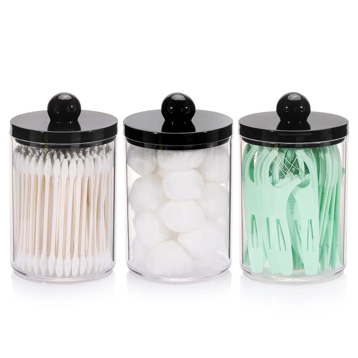 Three black-lidded plastic apothecary jars in a row