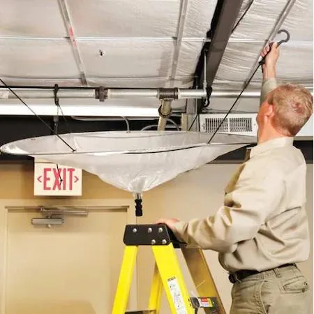 Clear rectangular leak diverter tarp with plastic hooks and PVC hose attached