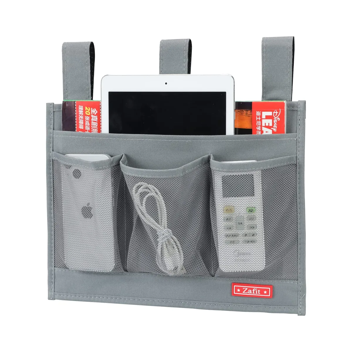 Grey bedside storage caddy with four pockets hanging from bed rail