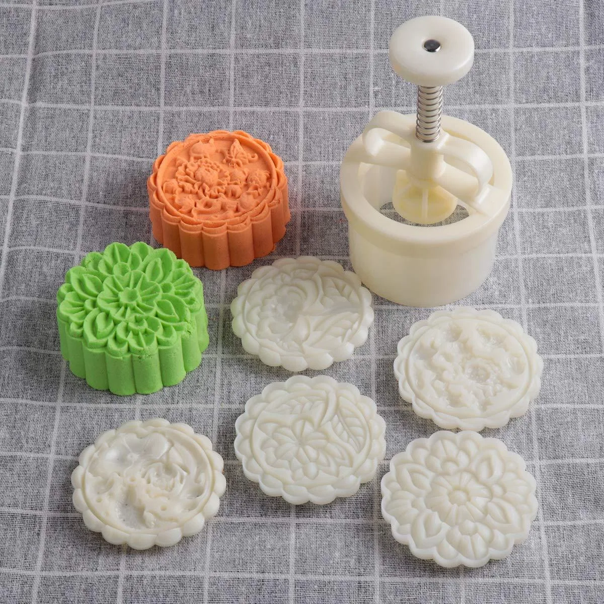 White adjustable mooncake stamp set with five patterned discs and turning knob handle