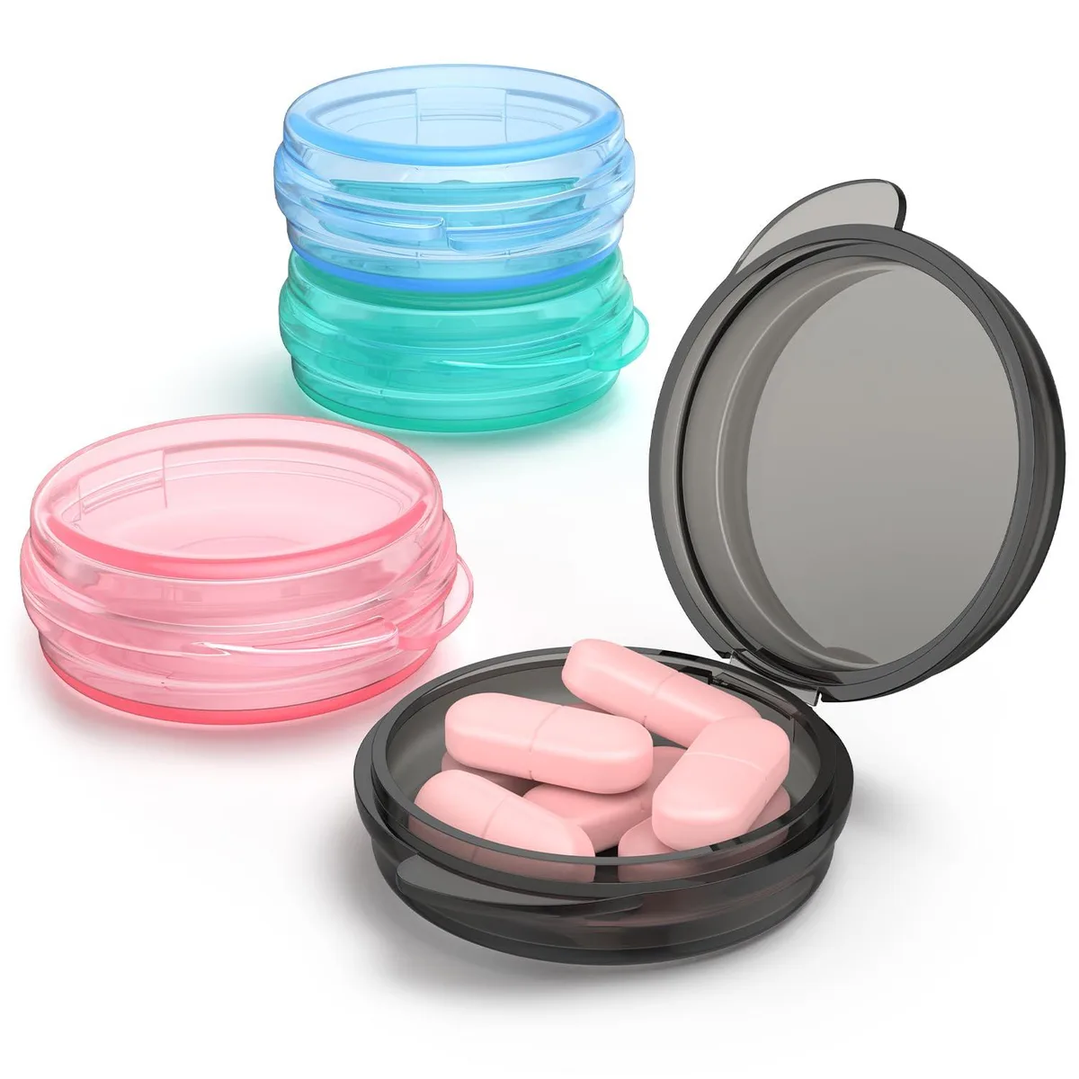 Four small round black pill boxes with snap lids