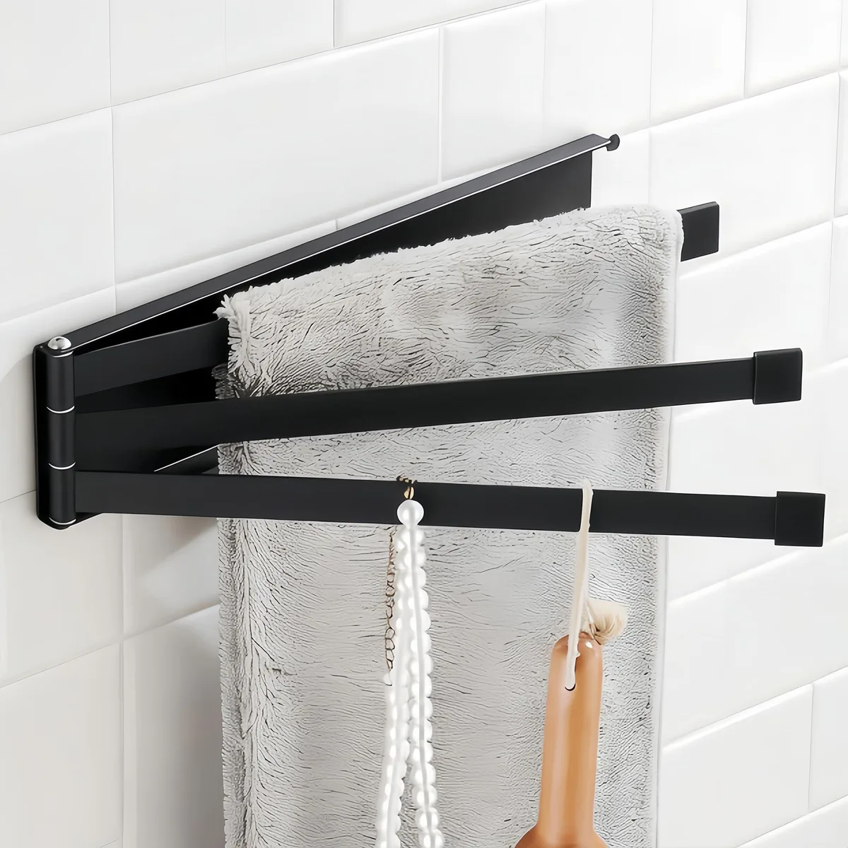 Three-arm black stainless steel towel rack folded flat against wall