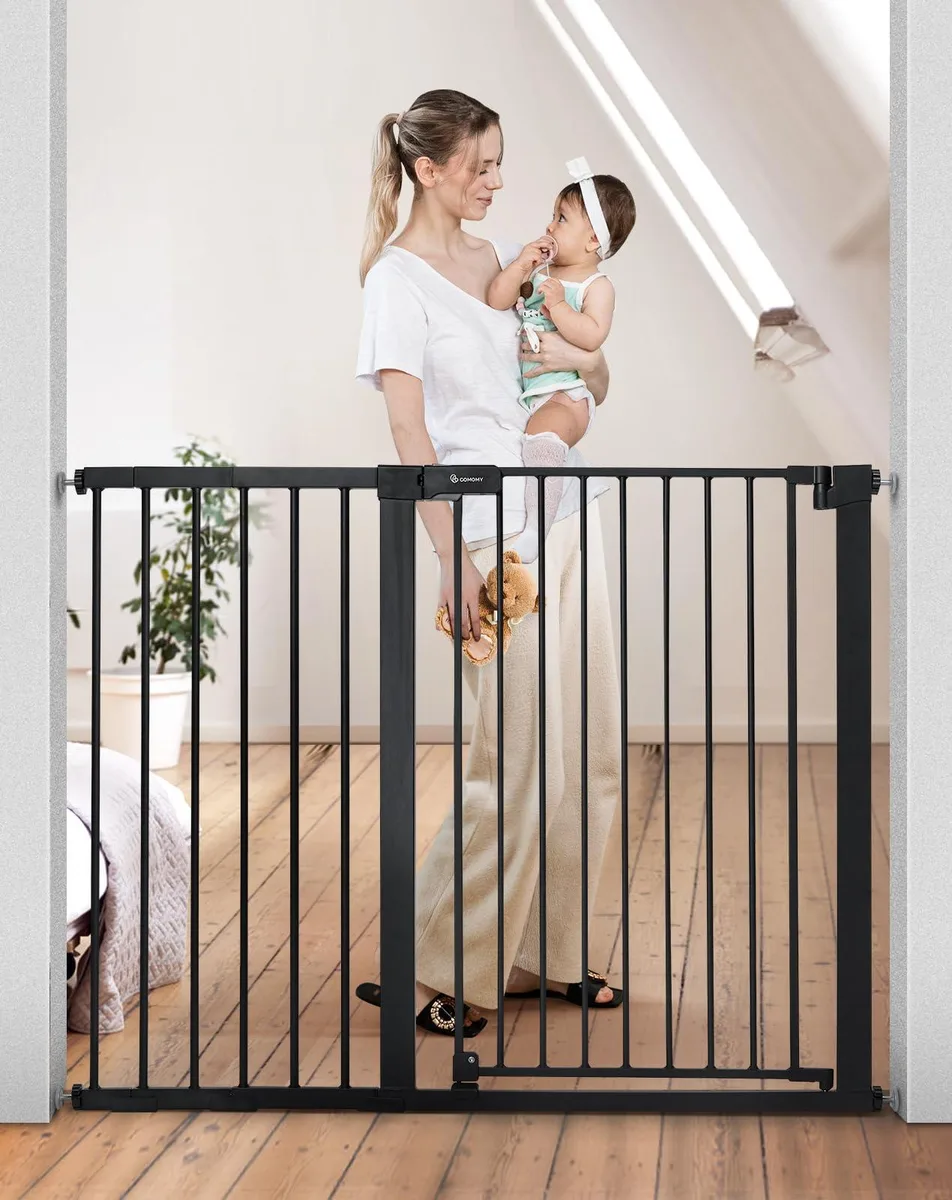Black metal baby gate with walk-through door and latch visible