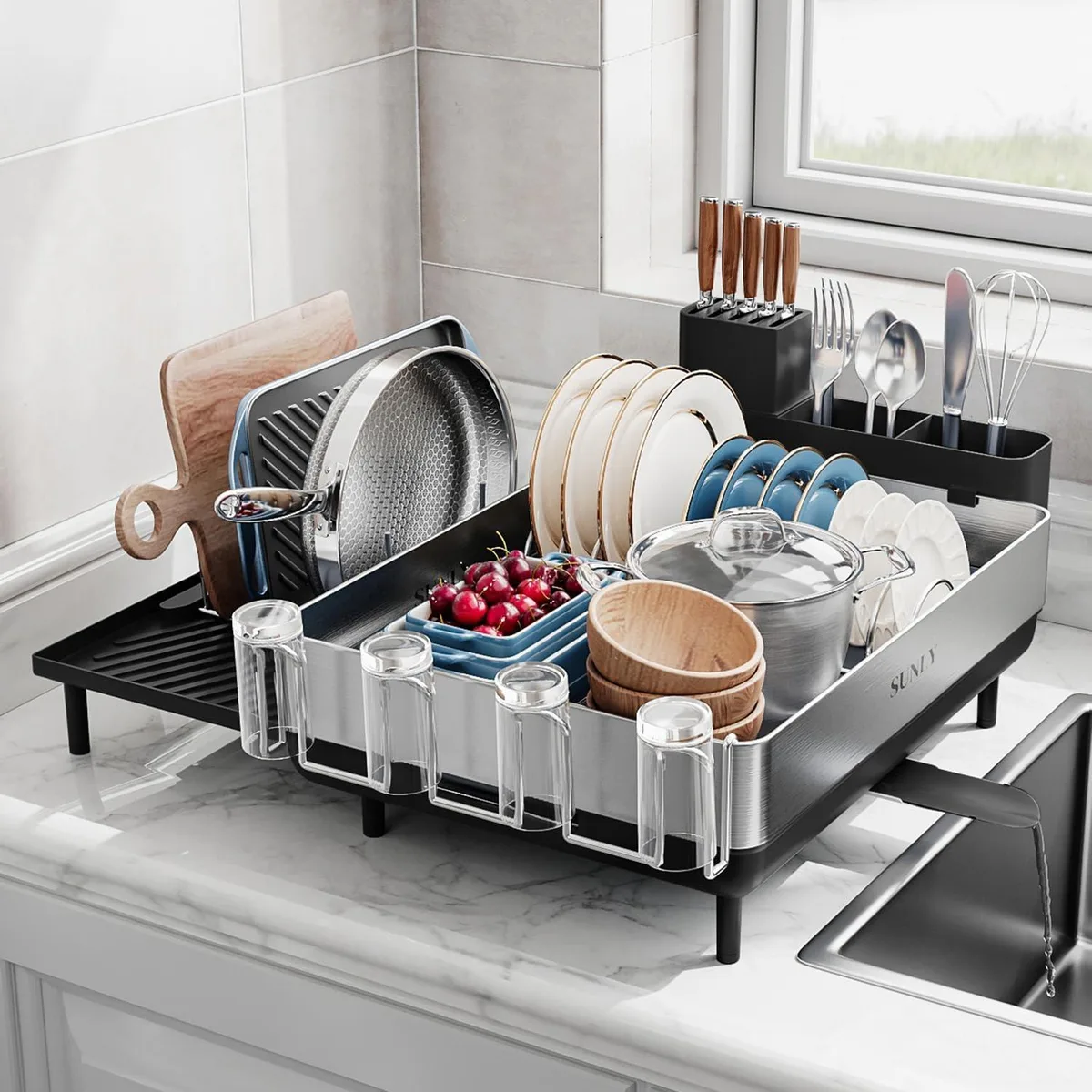Red plastic two-tier expandable dish rack, 34 inches wide, with flip-up pegs and drainboard