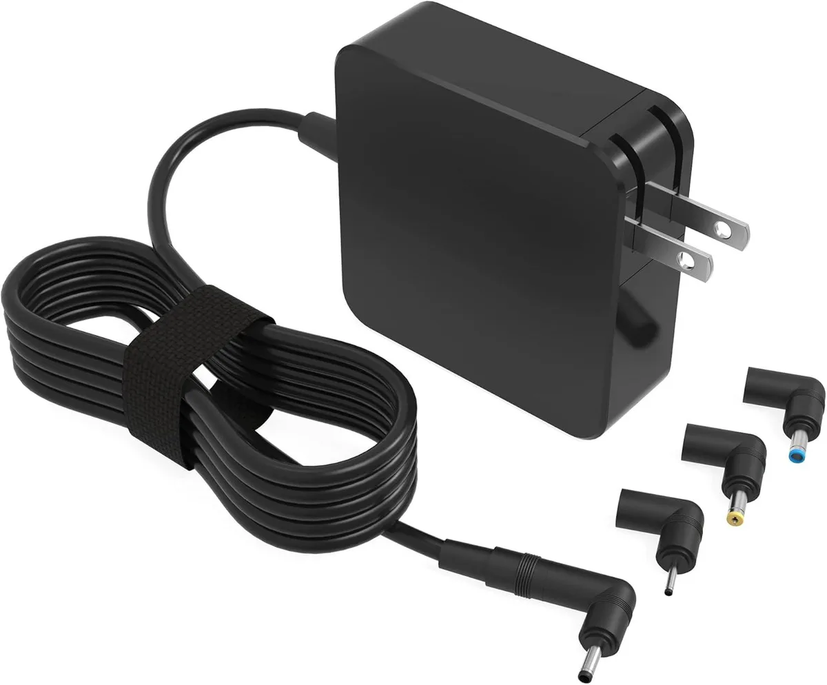 A compact black rectangular power adapter with a fixed cable and interchangeable barrel tips