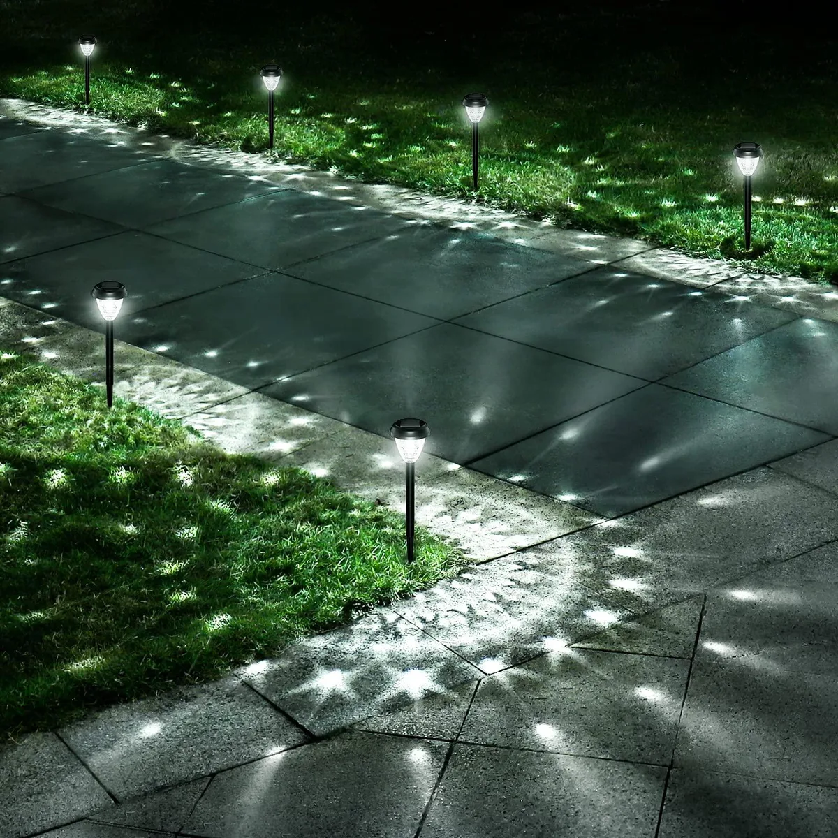Ten solar pathway lights with polished chrome finish and resin body standing on lawn