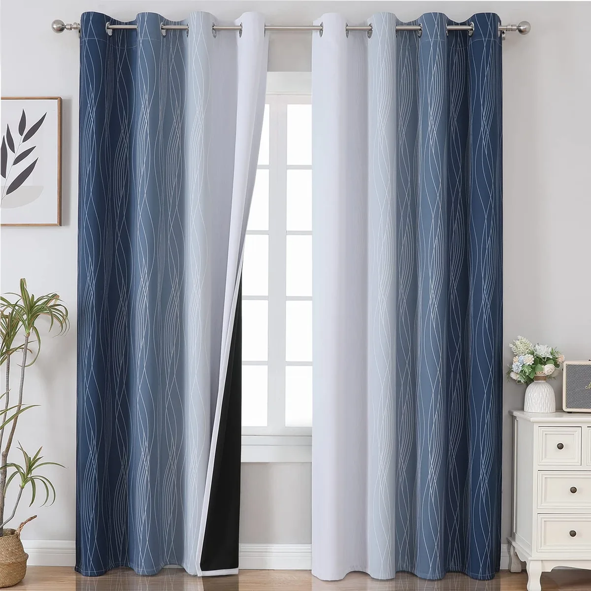 Two navy blue and greyish white ombre blackout curtain panels with wavy line design and silver grommets