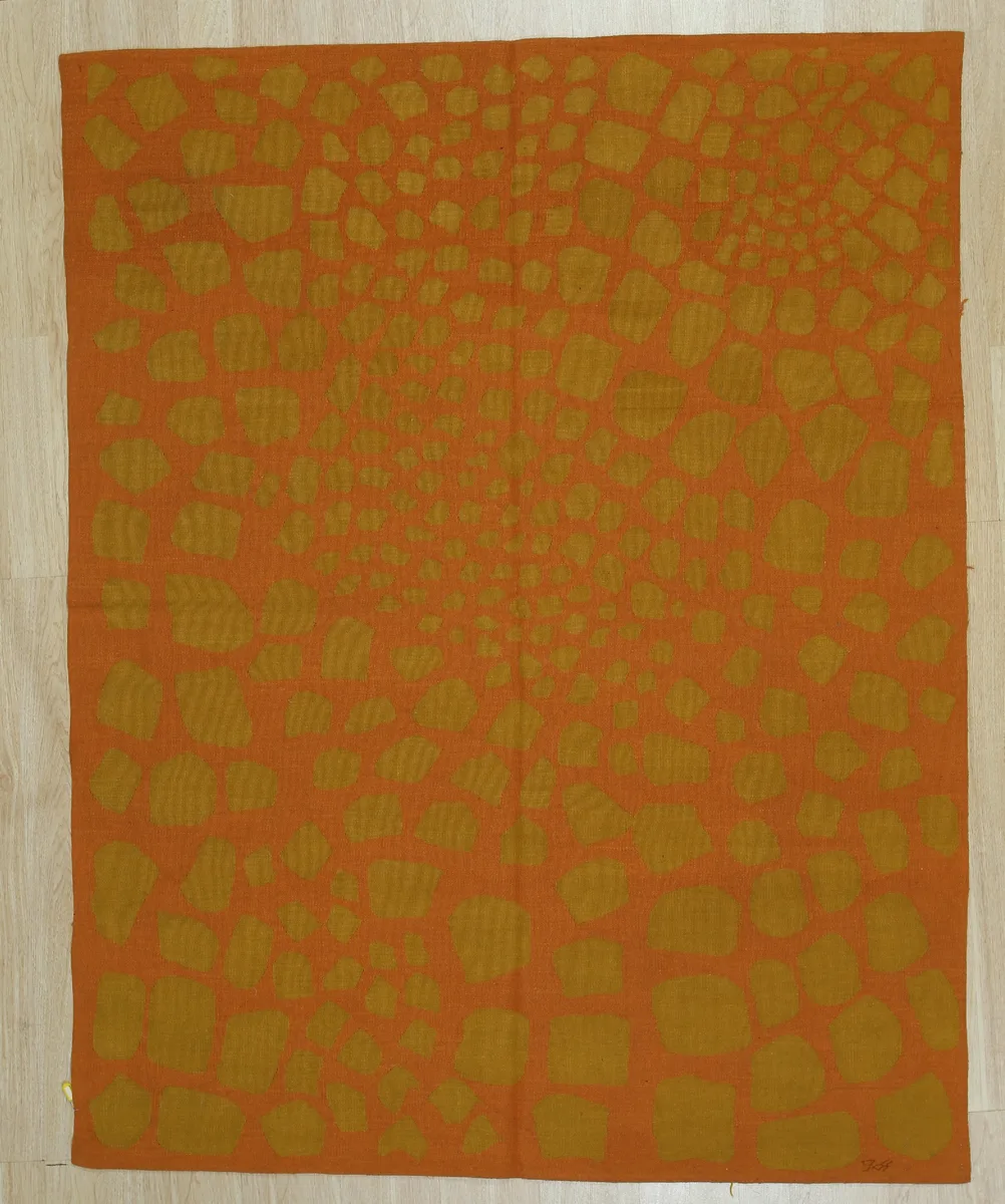 Handwoven rust wool flat weave area rug with plaid pattern and surged edges