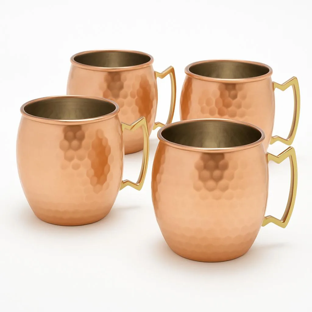 Set of four hammered copper mugs with brass handles