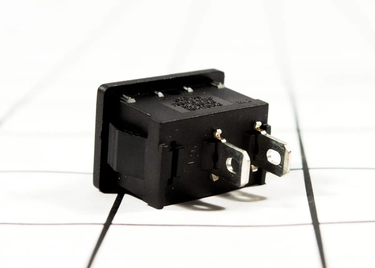 Small rectangular plastic light switch with two terminals