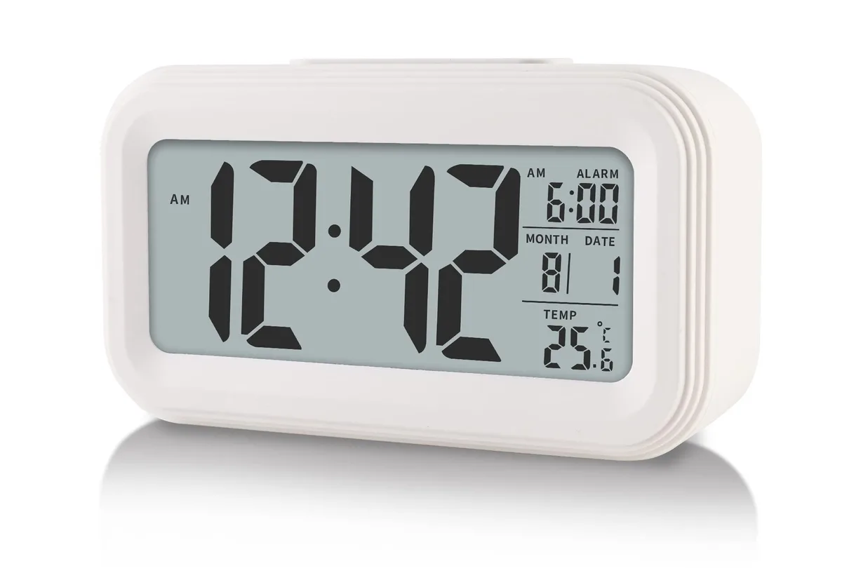 White rectangular digital clock with LCD display and top buttons