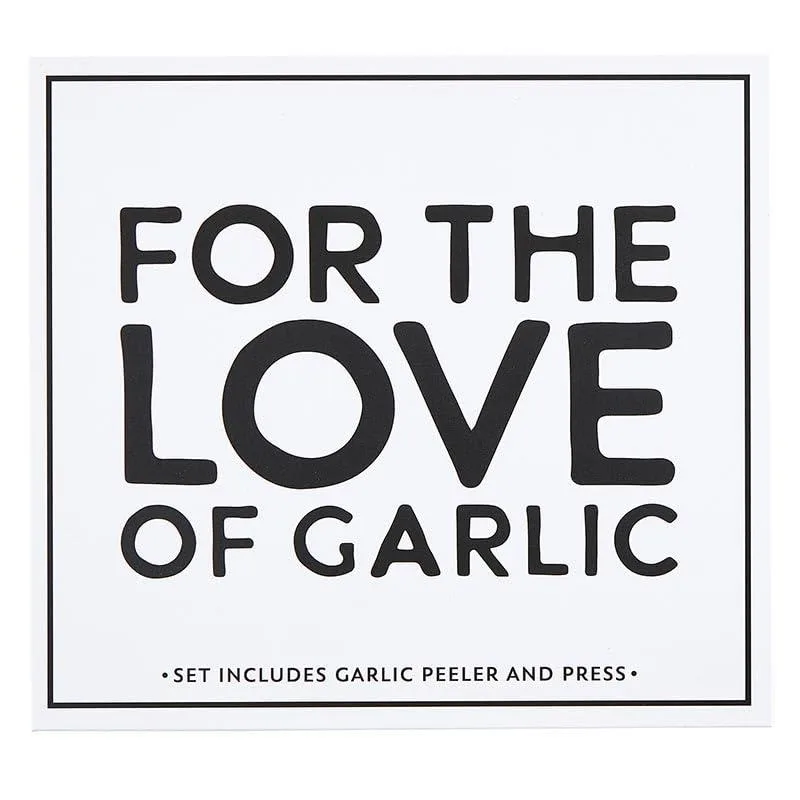 Black and white cardboard book-style gift box containing three garlic tools: peeler, classic press and rocker press