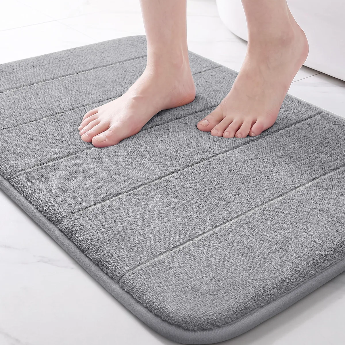 Grey rectangular bath mat, 24 by 17 inches, memory foam with coral velvet surface and PVC backing