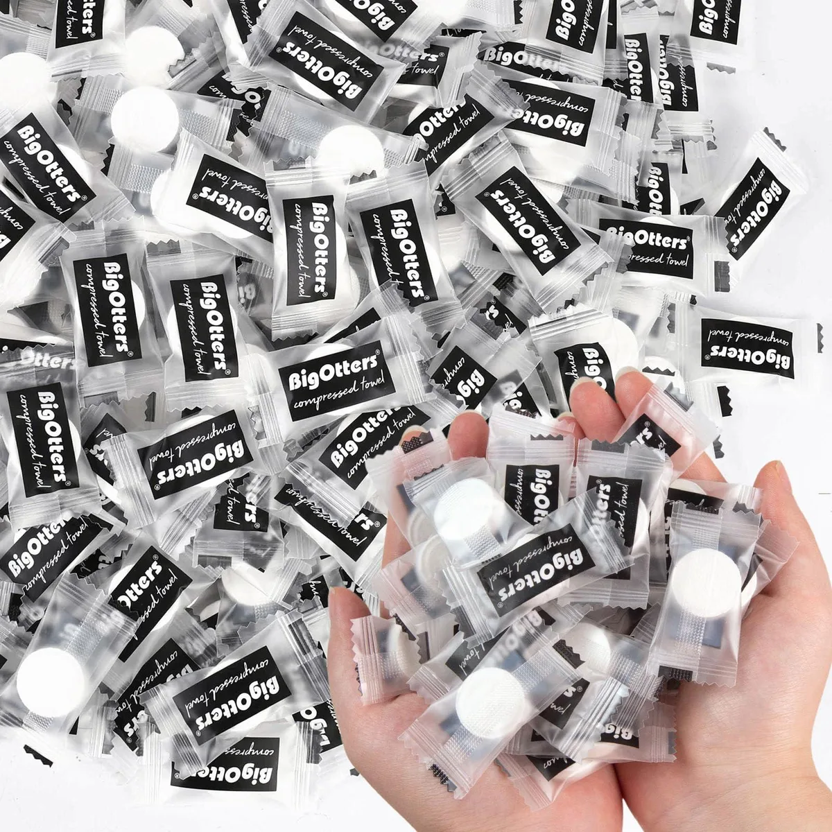 White cylindrical container holding 100 coin-sized compressed towel tablets