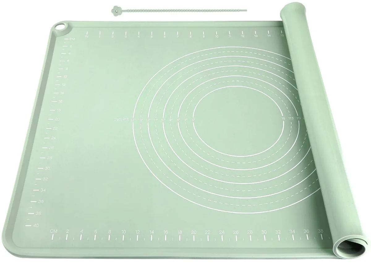 Light green rectangular silicone baking mat with raised edges and printed measurement guides