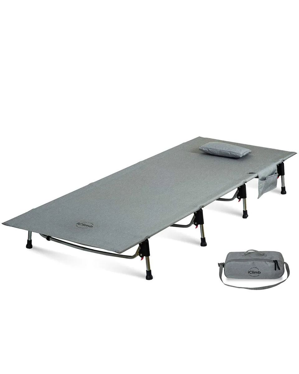 Grey folding cot with aluminium frame, fabric sleeping surface, side pockets and carry bag
