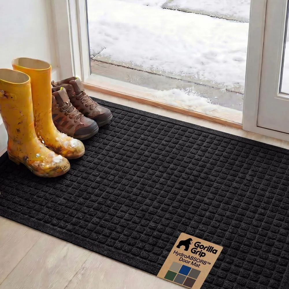 Black rectangular doormat with geometric raised pattern, low pile, rubber backing, 47 by 35 inches