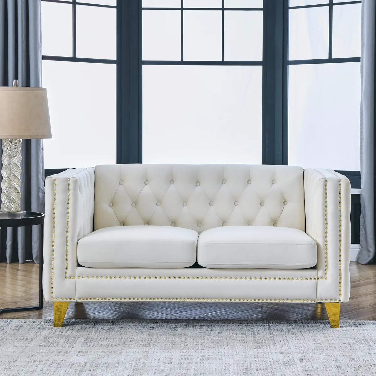 Beige velvet two-seat sofa with tufted buttons nailhead trim square arms and metal legs