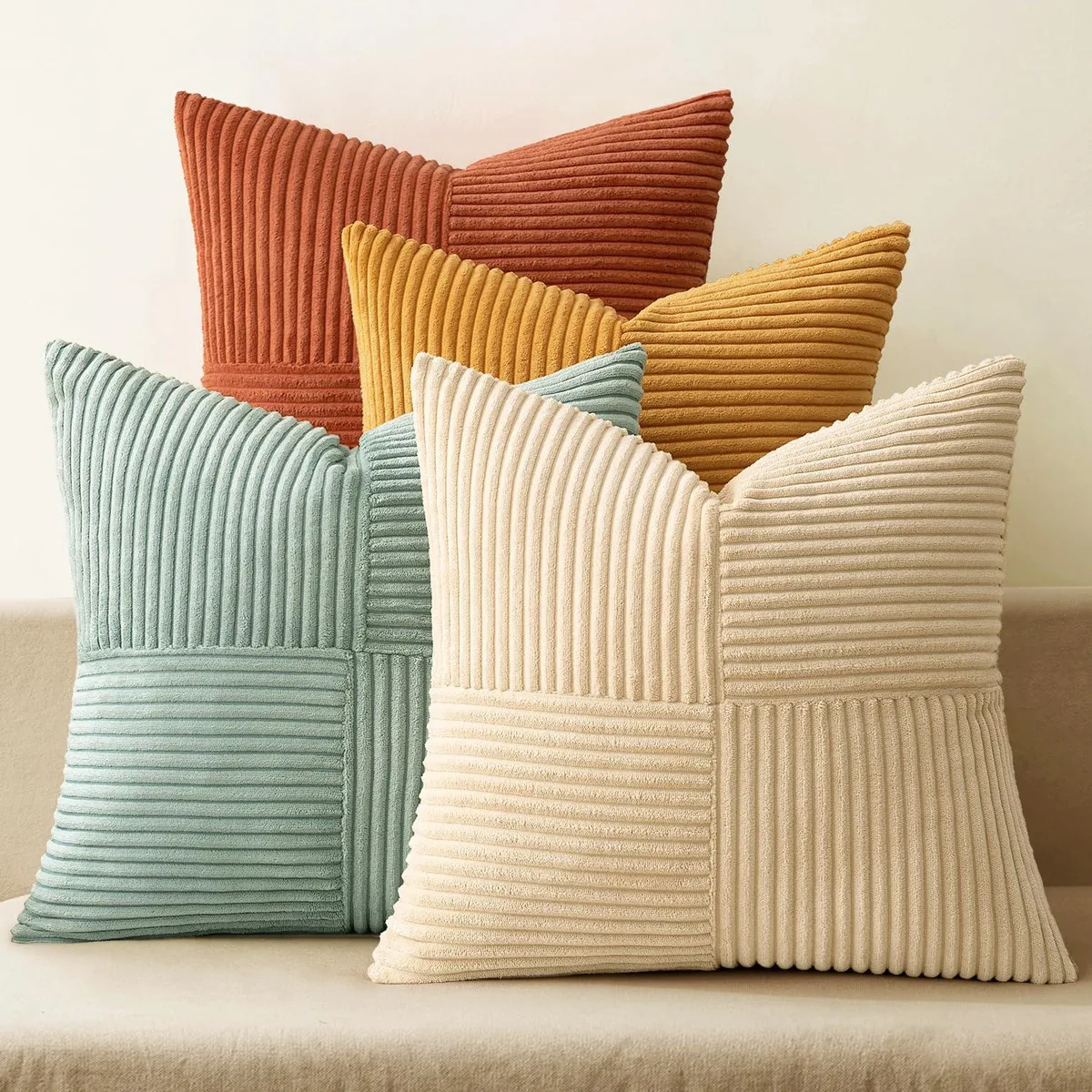 Four square 18-inch corduroy pillow covers in teal and orange patchwork stripes